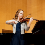 Sarah Bagin playing her violin in her minor violin recital.