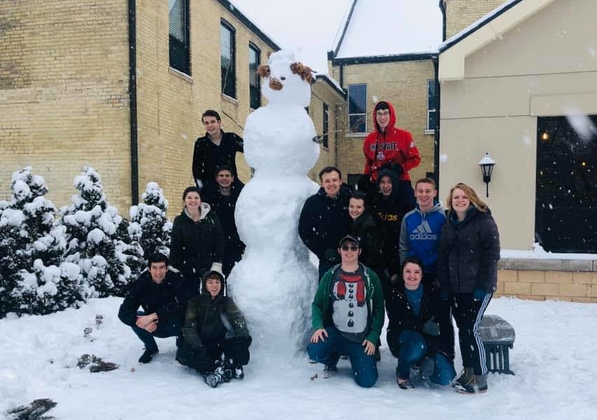 Students building a snowman